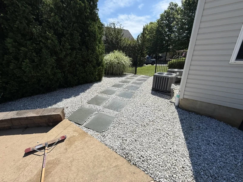 Stepping-stone walkway through decorative gravel beside a home