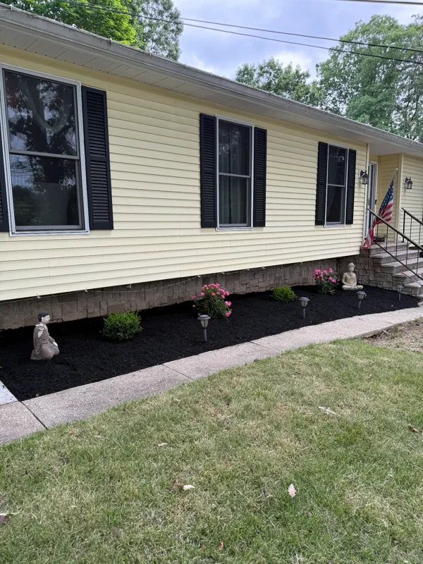 Fresh mulch and flowering plants along the front of a home