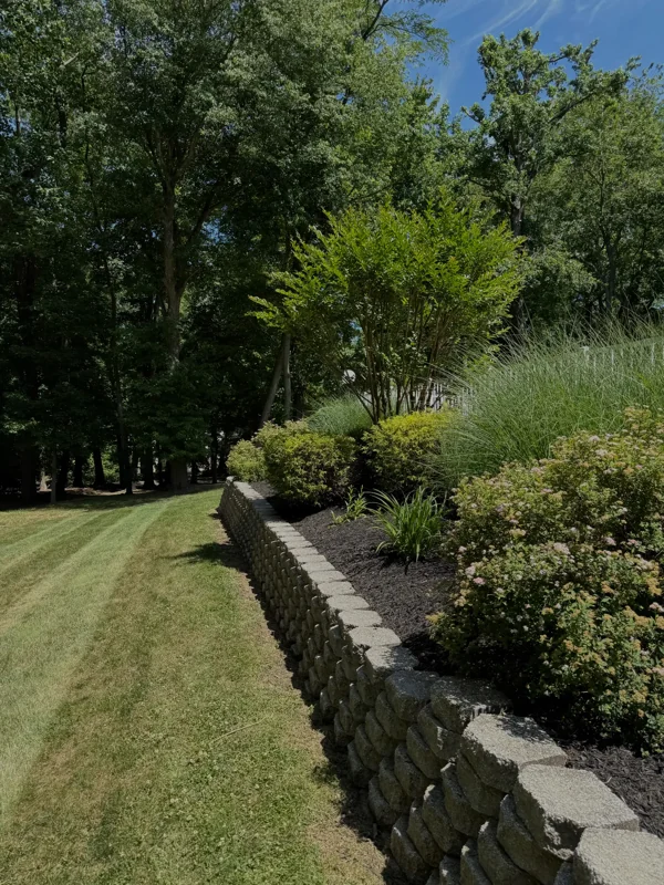 Retaining wall along a planted garden bed and lawn