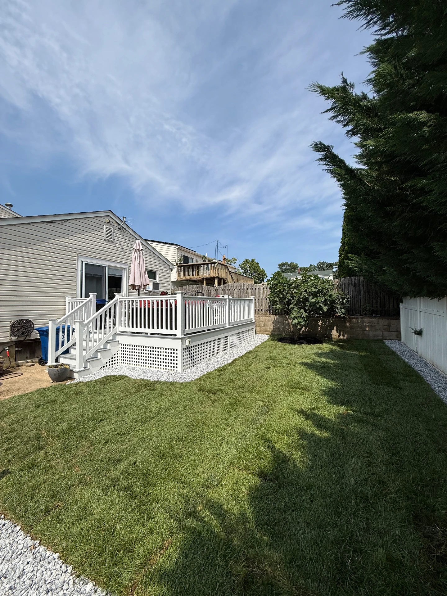 New sod and white stone borders in the same backyard after installation