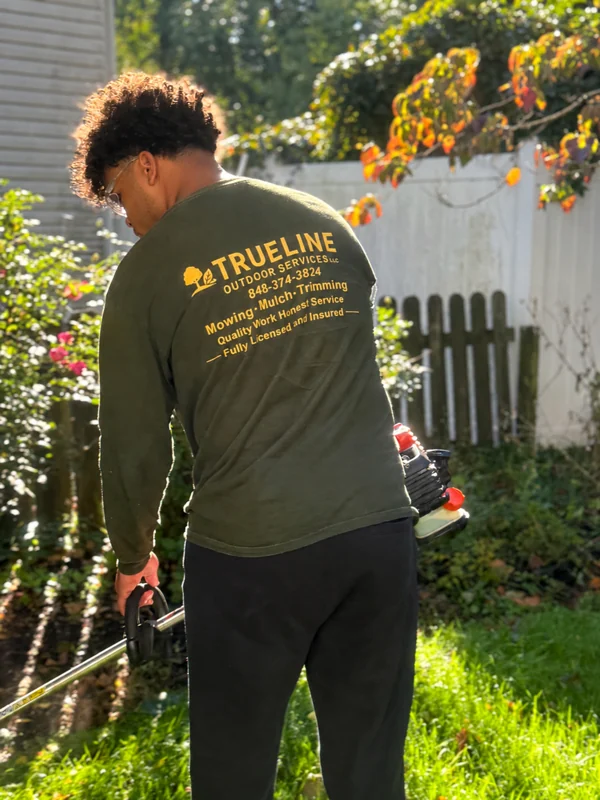 TrueLine landscaper working beside backyard plantings