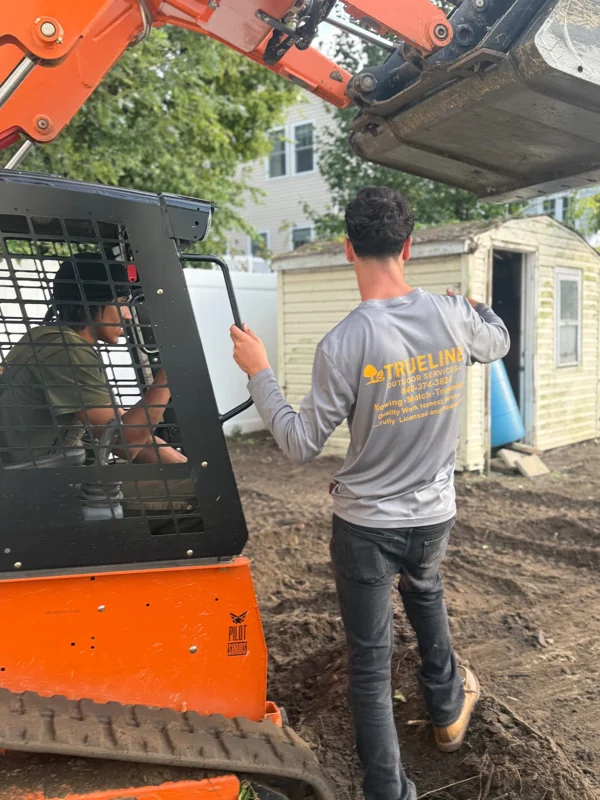 TrueLine crew member beside landscaping equipment on a job site