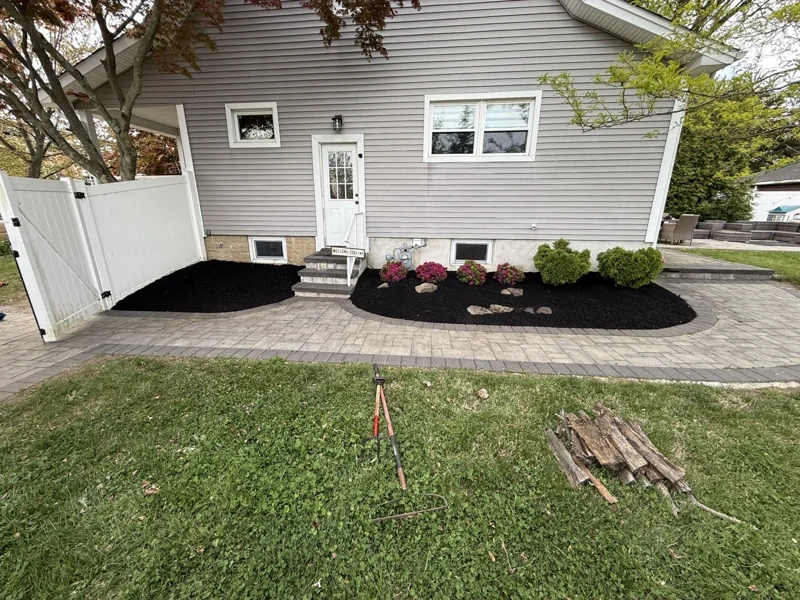Paver walkway around a home with mulched flowering beds